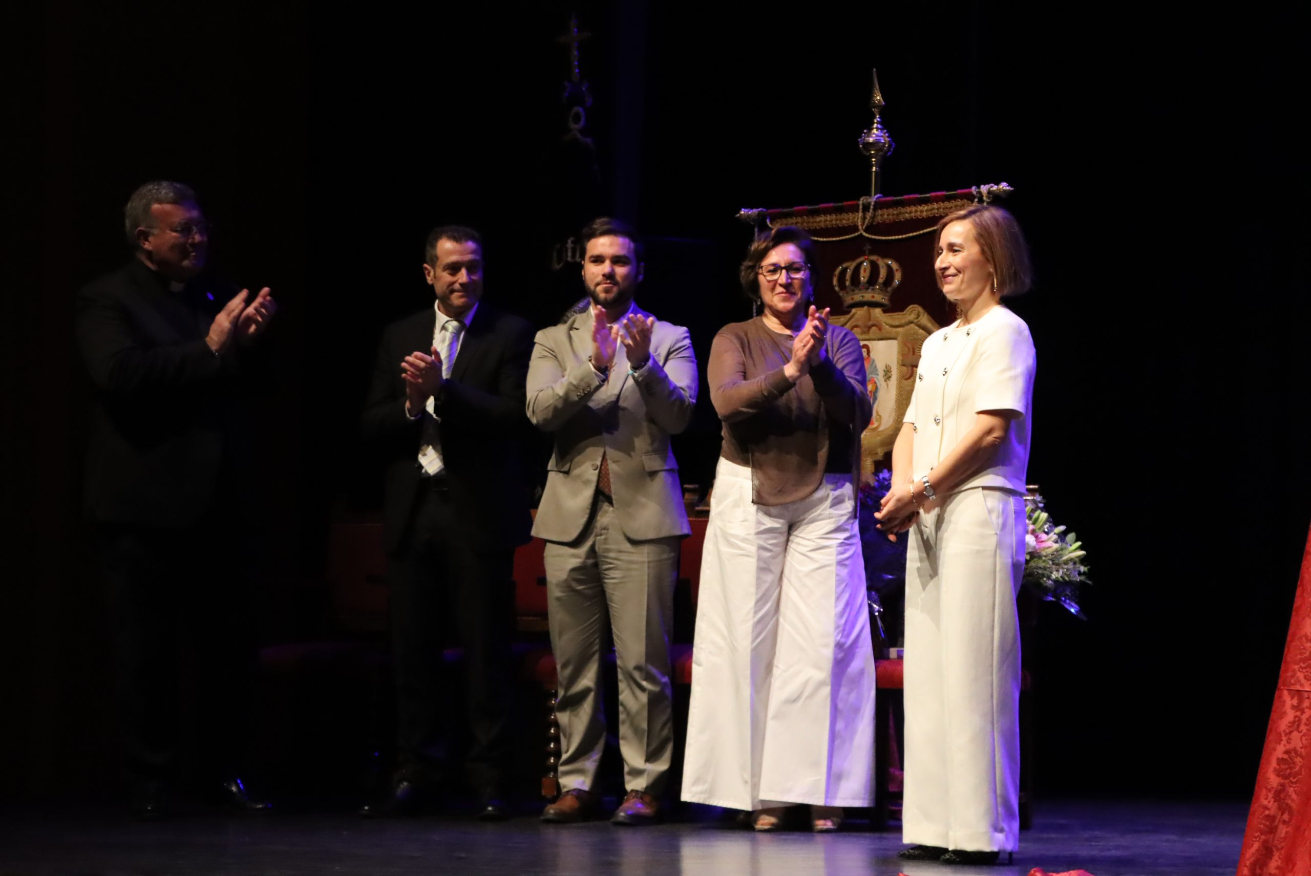 Ana Holguín recibiendo el aplauso del alcalde, párroco, presidente de la Junta de cofradías y de su compañera y presentadora